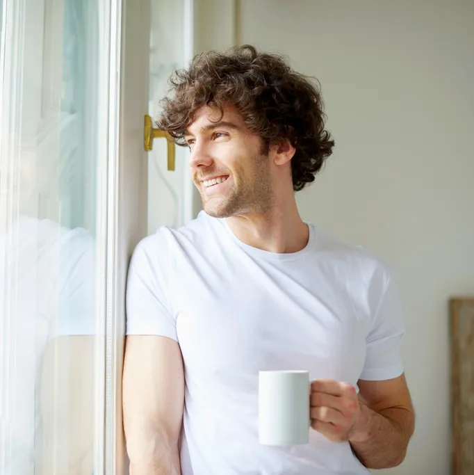 Zufriedener Kunde zu Hause am Fenster